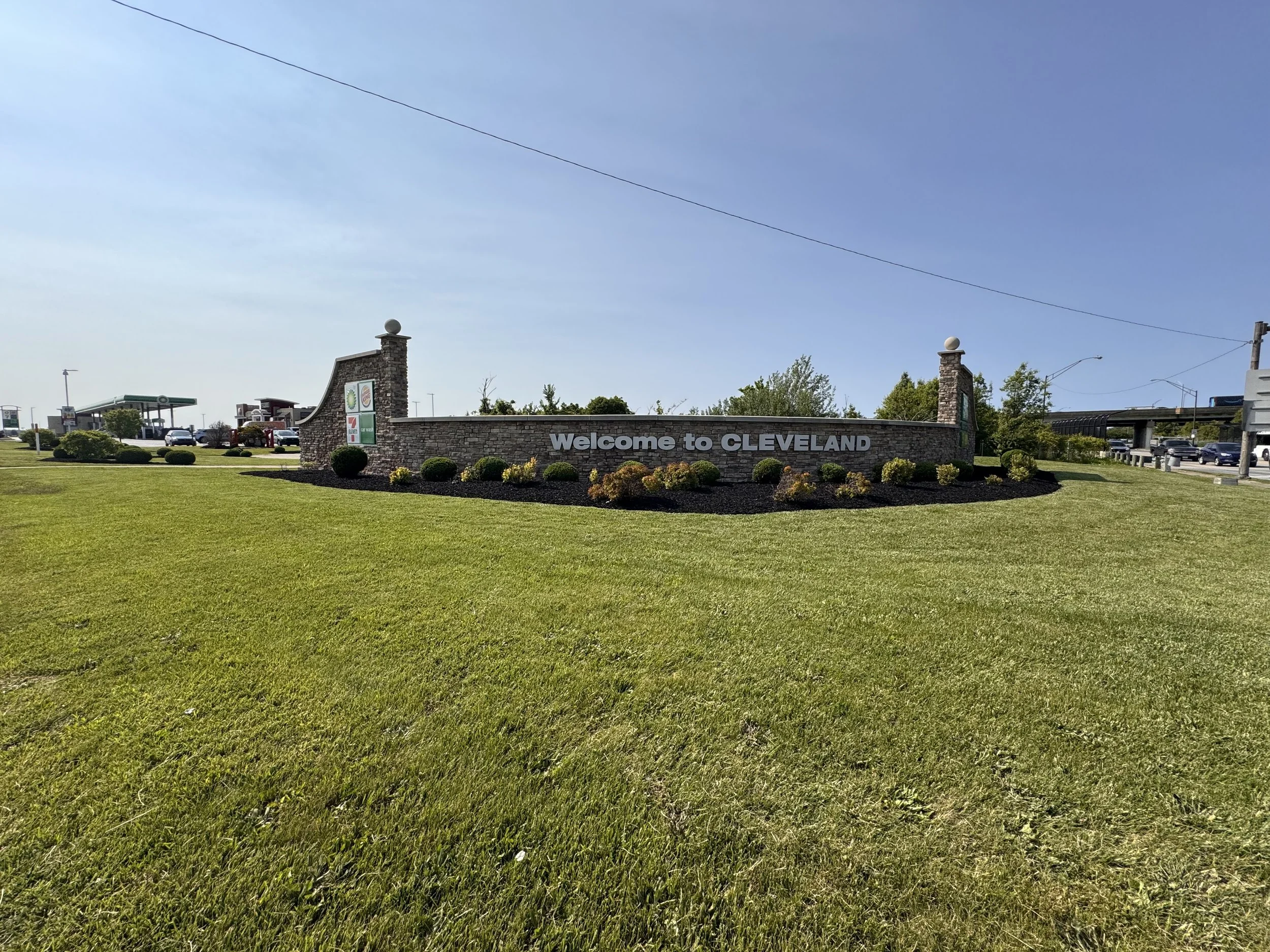 Landscaped Welcome to Cleveland sign with brick pillars and manicured beds