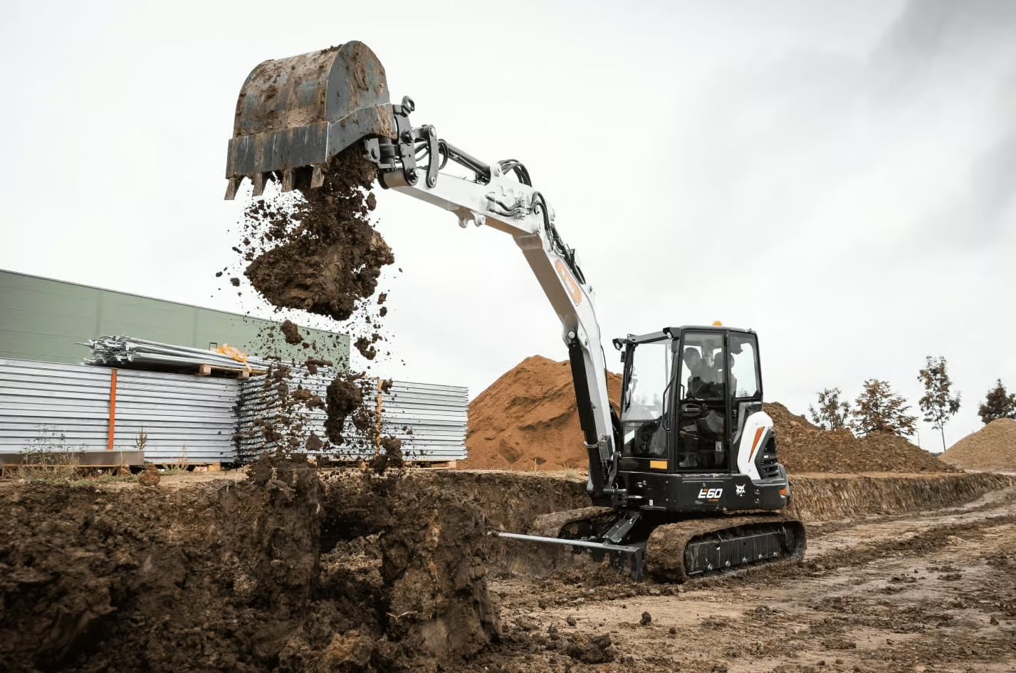 Compact excavator working in a residential backyard during site work