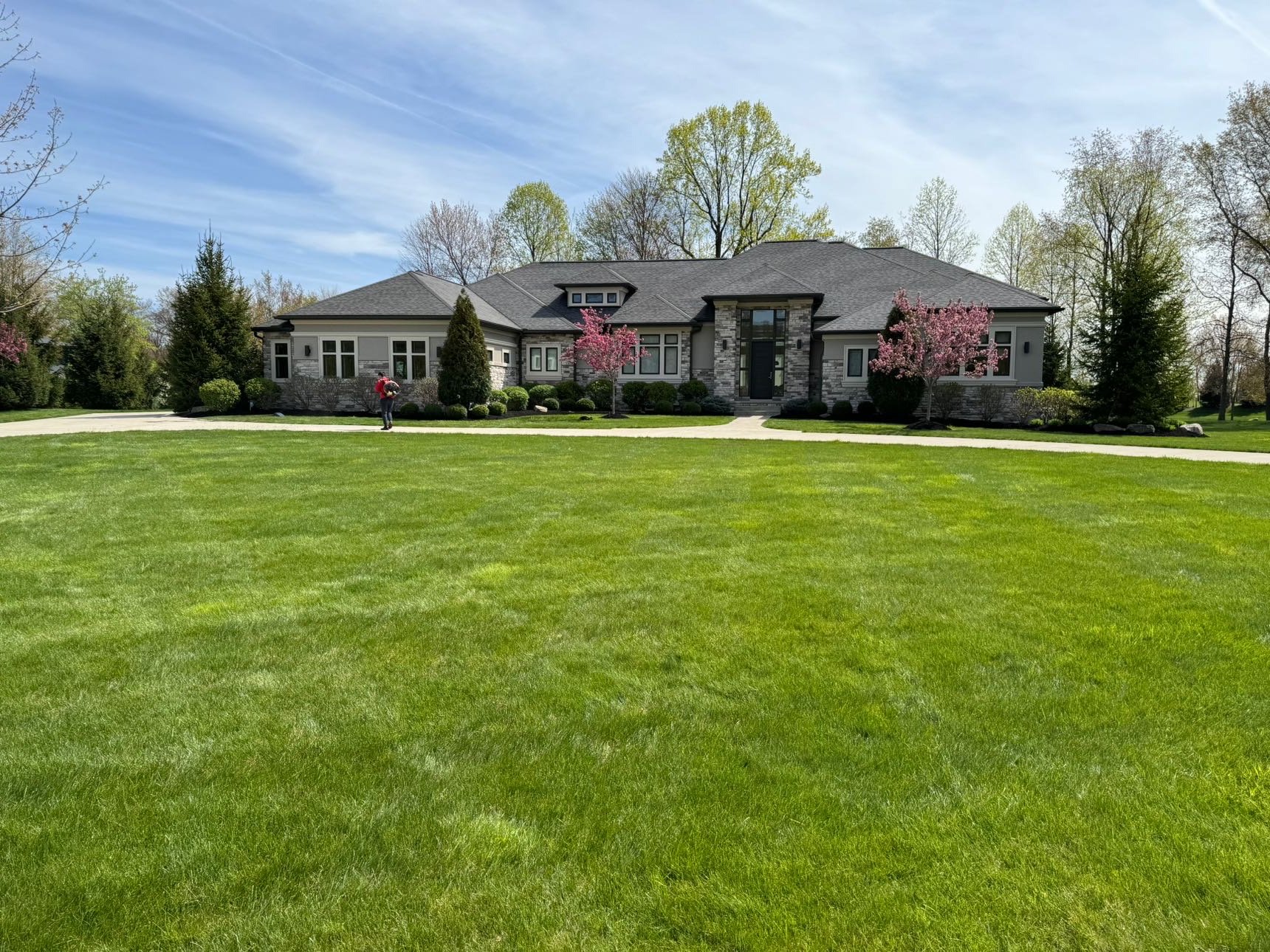 Lawn with crisp striped mowing pattern in front of a large home