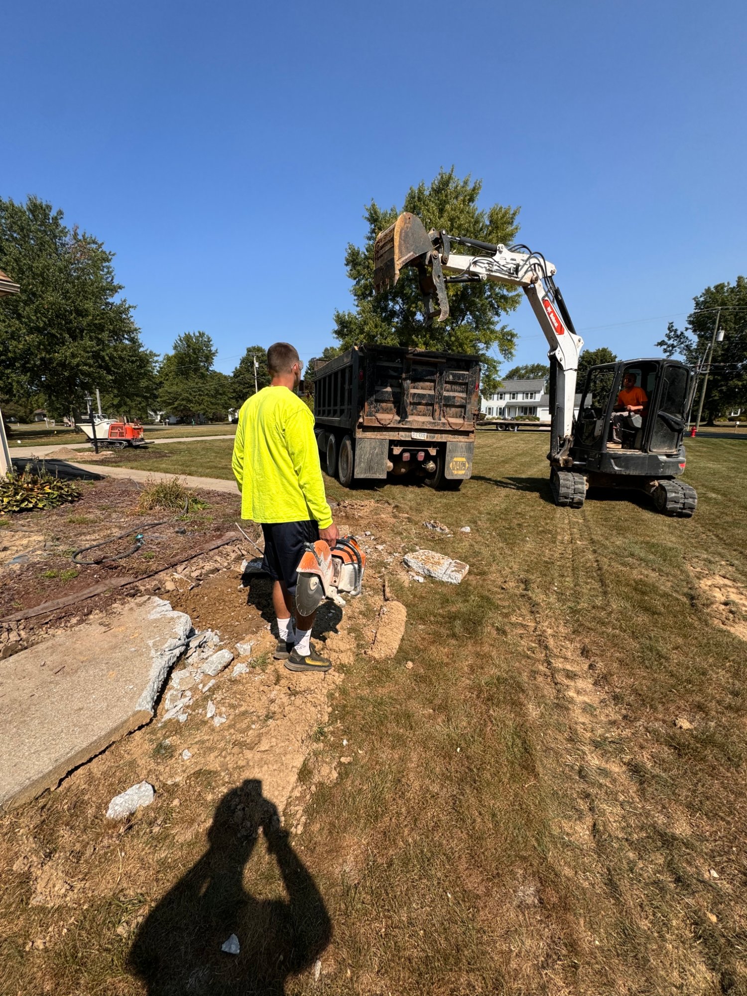 Excavation and concrete removal with an excavator loading a dump truck