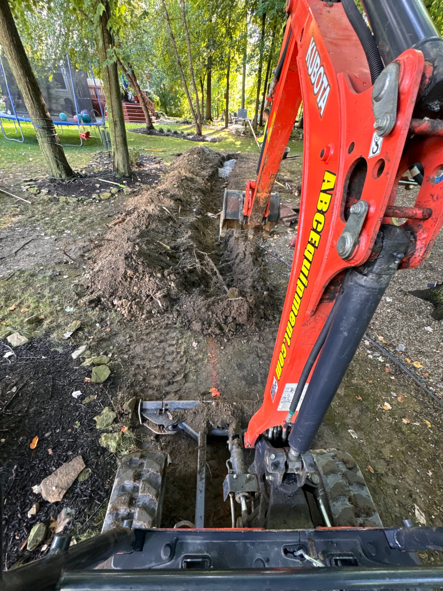Excavator removing a tree stump during lot clearing
