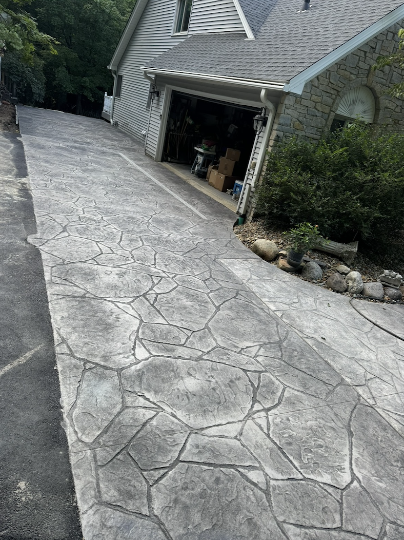Stamped stone-pattern concrete driveway leading to a home garage